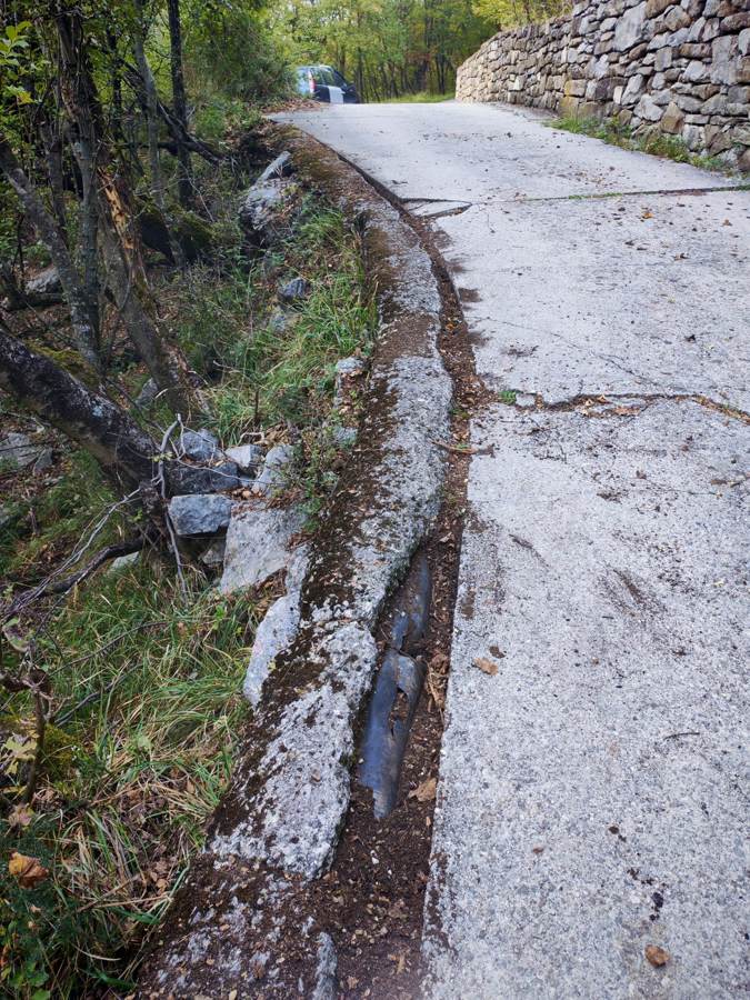 Spodkopan rob ceste in odkrita kabelska kanalizacija / Bordo scalzato e cavidotto scoperto